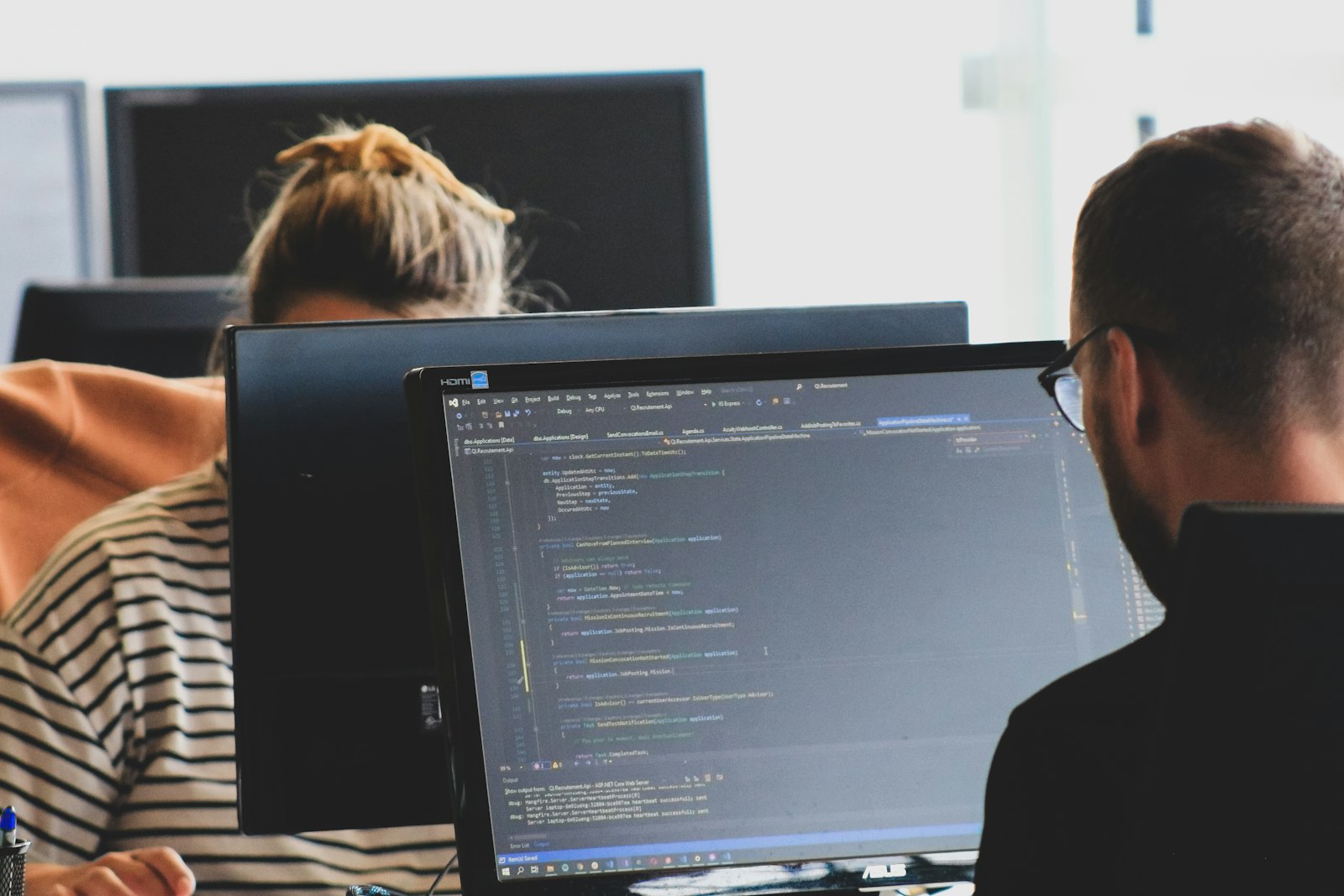 Desenvolvedores programando em dois monitores